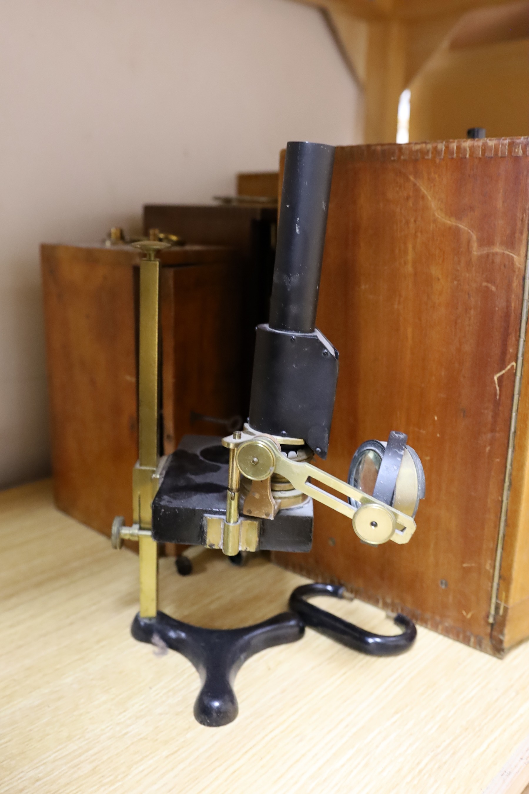 Five cased microscopes, another uncased and a pine microscope slide cabinet, latter 25.5 cm height